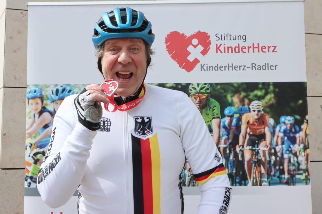 Eine herzförmige Medaille für ein großes Herz: Schauspieler Uwe Rohde fährt eine große HerzRadtour durch fast jedes Bundesland. Fotos: Patrick Becher